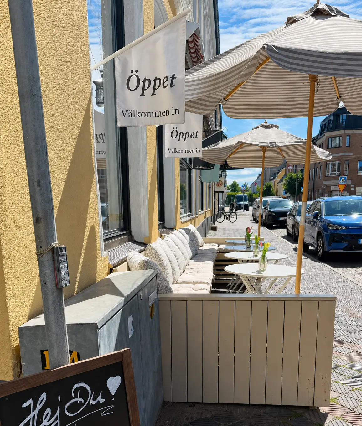 Uteservering med Öppet-flaggor och parasoller i Landskrona