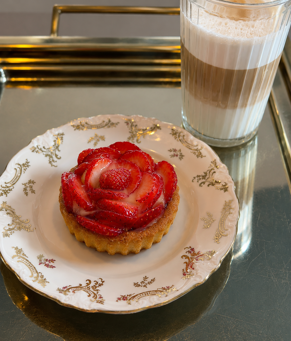 Jordgubbstårta och caffè latte på guldbricka hos Fika & Relax Lounge